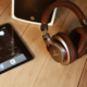 Speaker, headphones, and IPad on top of a wooden table